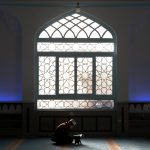 Seorang muslim yang sedang membaca Al-Quran, salah satu amalan yang sangat baik dan dianjurkan saat bulan Ramadhan